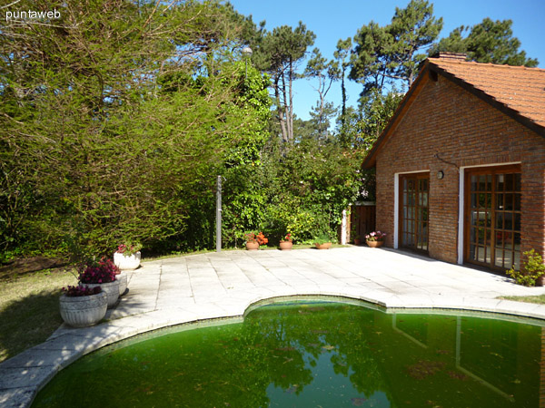 Piscina y solarium prximo a parrillero cerrado.