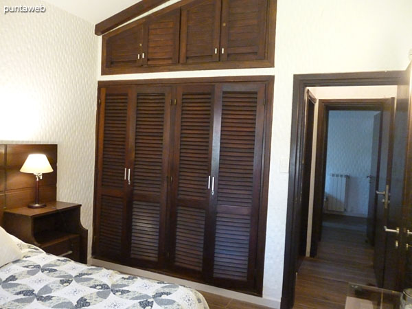 Vista general del dormitorio principal situado al frente de la casa sobre el lateral sur.<br><br>Est� acondicionado con una cama matrimonial, importante respaldo en madera y placard en madera de pared a pared y del piso al techo.<br><br>La ventana brinda vistas al jard�n frontal.