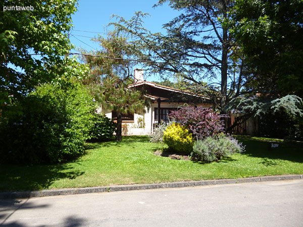 Fachada de la casa orientada al este. Entorno de barrio residencial rodeado de verdes.