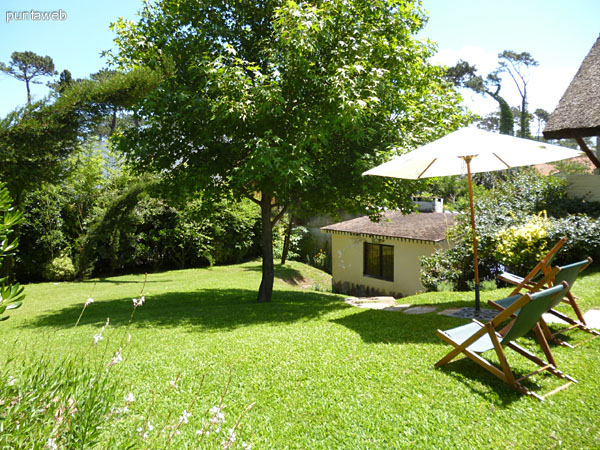 Barbacoa techada con quincho y acondicionada con gran mesa en madera con capacidad para 10 personas en sillas plegables.