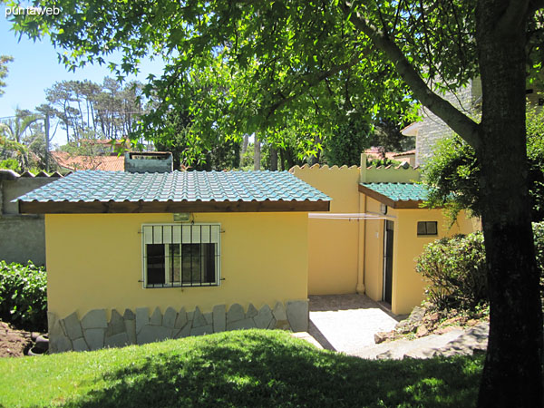 Barbacoa techada con quincho y acondicionada con gran mesa en madera con capacidad para 10 personas en sillas plegables.